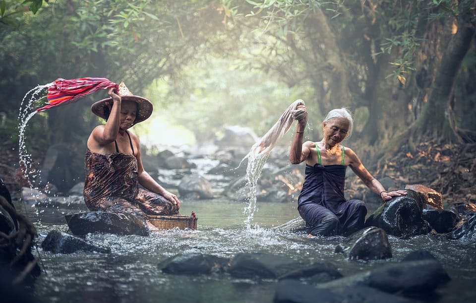 Kvinnor tvättar i floden